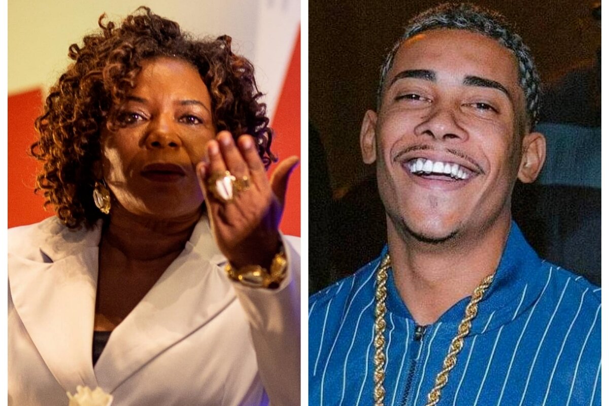 Margareth Menezes de branco mandando beijo - Poze do Rodo, sorrindo, de camisa azul
